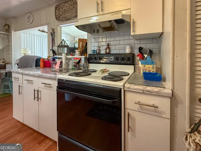 a kitchen with stainless steel appliances granite countertop a stove and cabinets