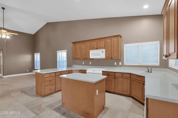 a large kitchen with granite countertop a large counter top appliances and cabinets