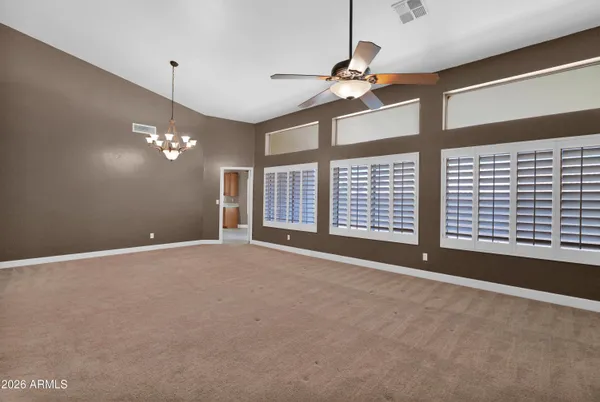 a view of an empty room with a chandelier fan
