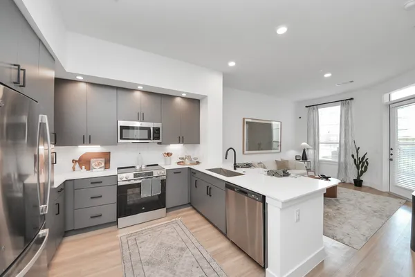 a bedroom with a bed a chandelier and dresser