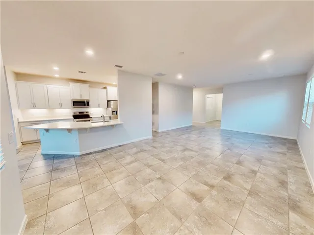 a view of kitchen with kitchen island microwave and cabinets