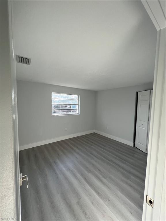 5345 Hardee Street Naples, FL 34113 - Photo 18 of 20 an empty room with wooden floor and windows