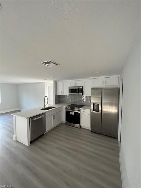 5345 Hardee Street Naples, FL 34113 - Photo 7 of 20 a large kitchen with cabinets wooden floor and stainless steel appliances