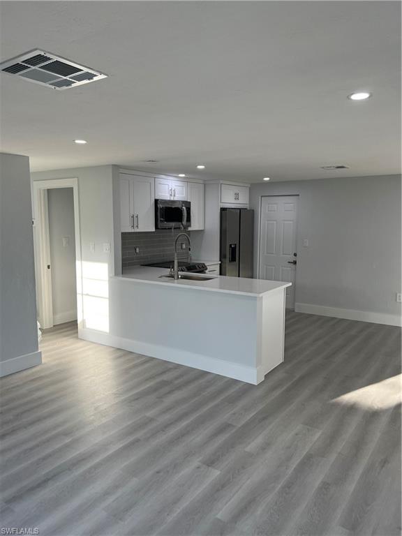 5345 Hardee Street Naples, FL 34113 - Photo 8 of 20 a view of kitchen with kitchen island stainless steel appliances a sink cabinets and wooden floor