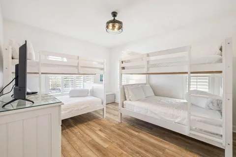 a bedroom with a bed and a flat tv screen on dresser