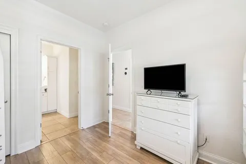a room with a flat screen tv and a dresser