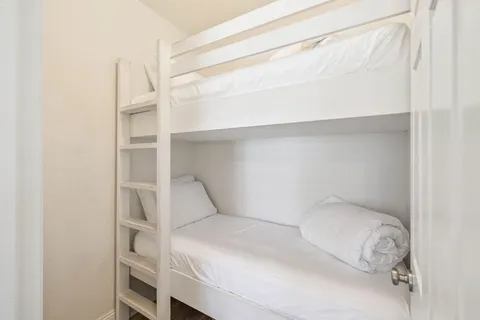a bedroom with a bed and a white cabinet