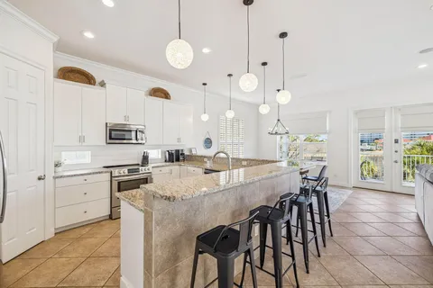a large kitchen with kitchen island a table and chairs in it