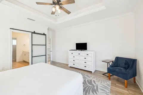 a bedroom with a bed dresser and flat screen tv