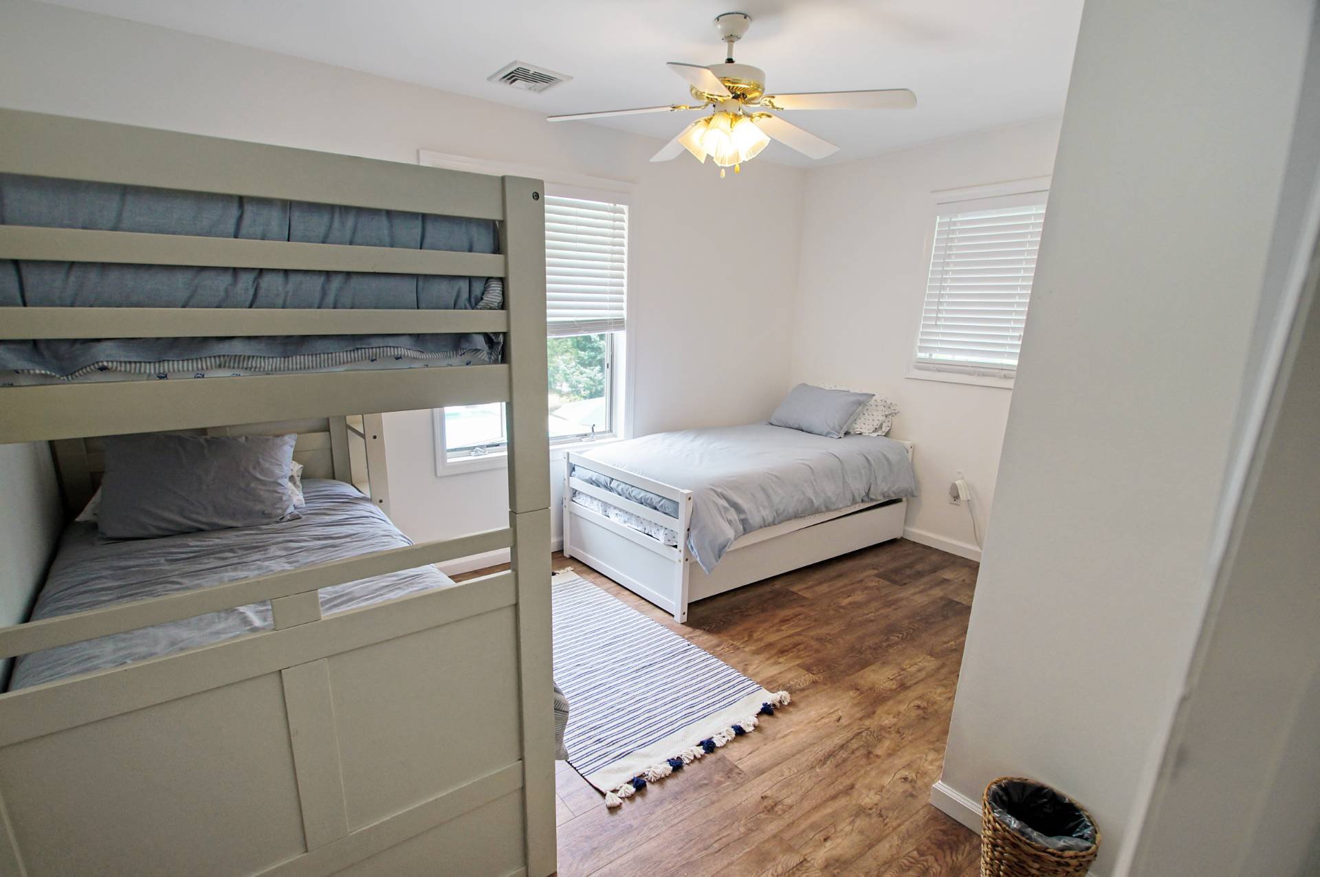 16 Norbury Road Hampton Bays, NY 11946 - Photo 11 of 32 a bedroom with a bed and a chandelier