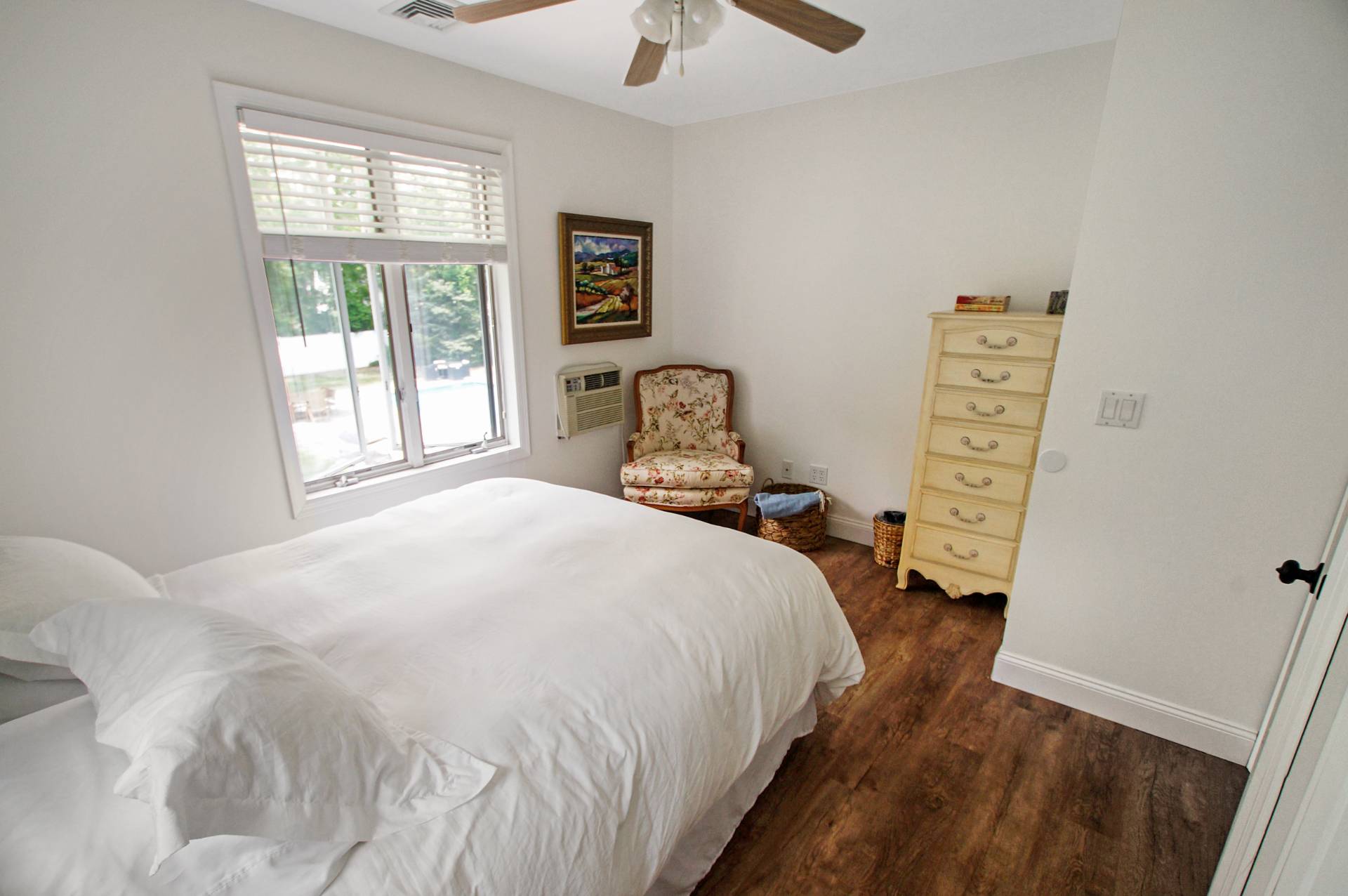 16 Norbury Road Hampton Bays, NY 11946 - Photo 14 of 32 a bedroom with a bed a window and a chandelier
