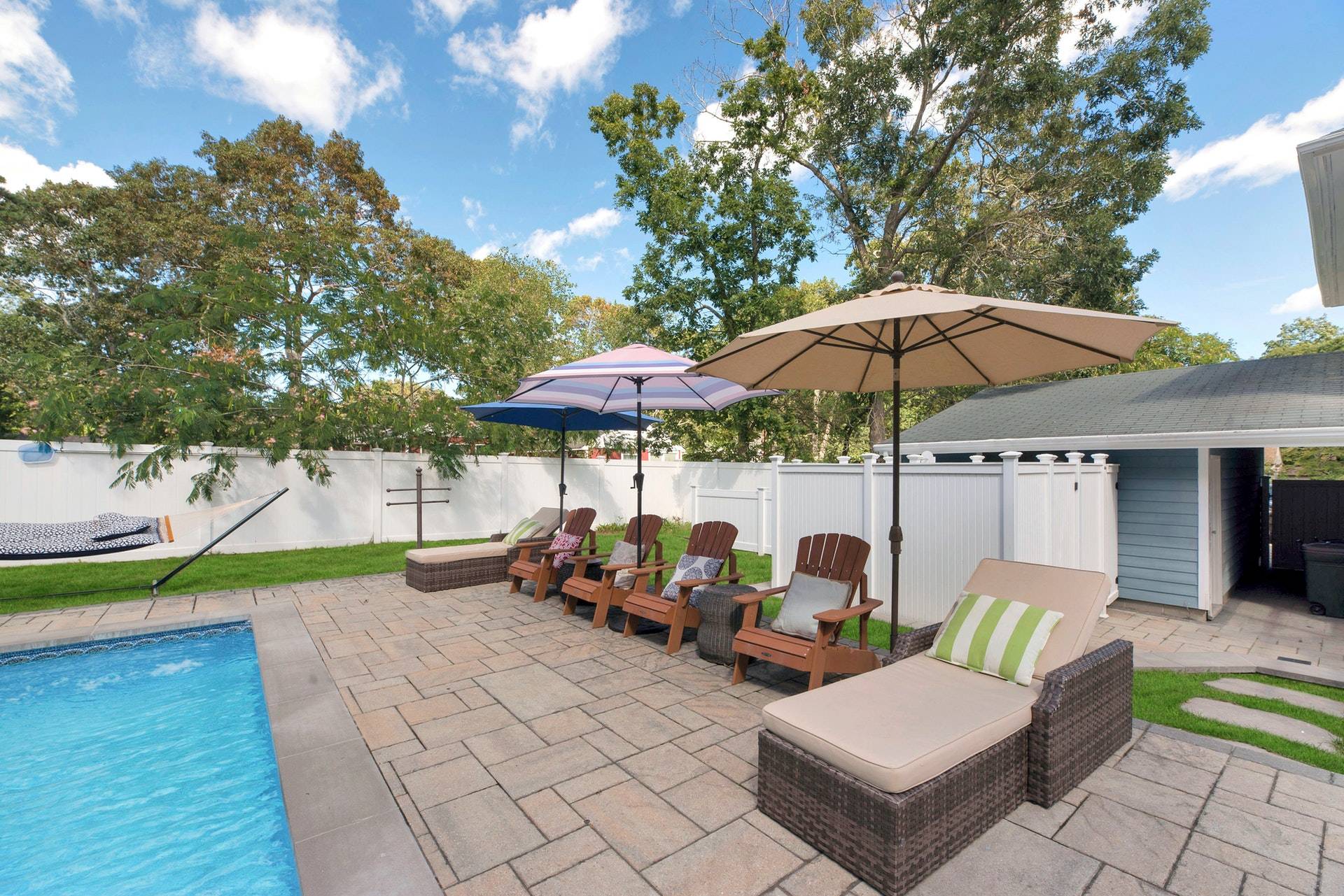 16 Norbury Road Hampton Bays, NY 11946 - Photo 21 of 32 a view of a patio with a table and chairs under an umbrella