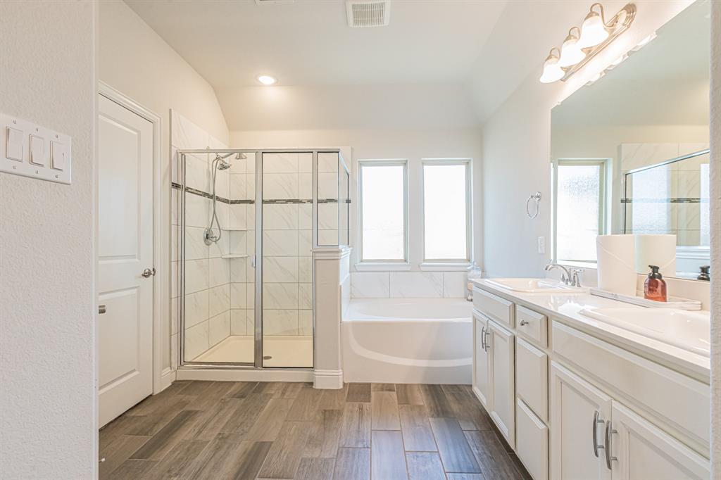 304 Adam Way Euless, TX 76040 - Photo 22 of 39 Bathroom featuring double vanity, a garden tub, a shower stall, dark wood-style floors, and recessed lighting