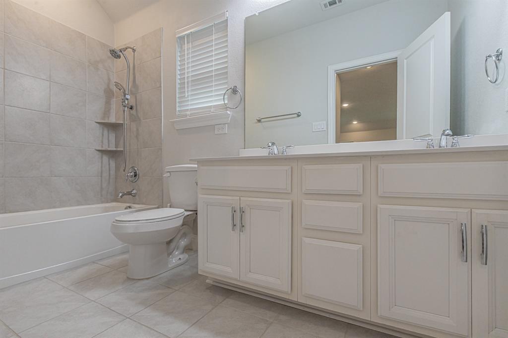 304 Adam Way Euless, TX 76040 - Photo 30 of 39 Bathroom with double vanity, shower / bath combination, and light tile patterned flooring