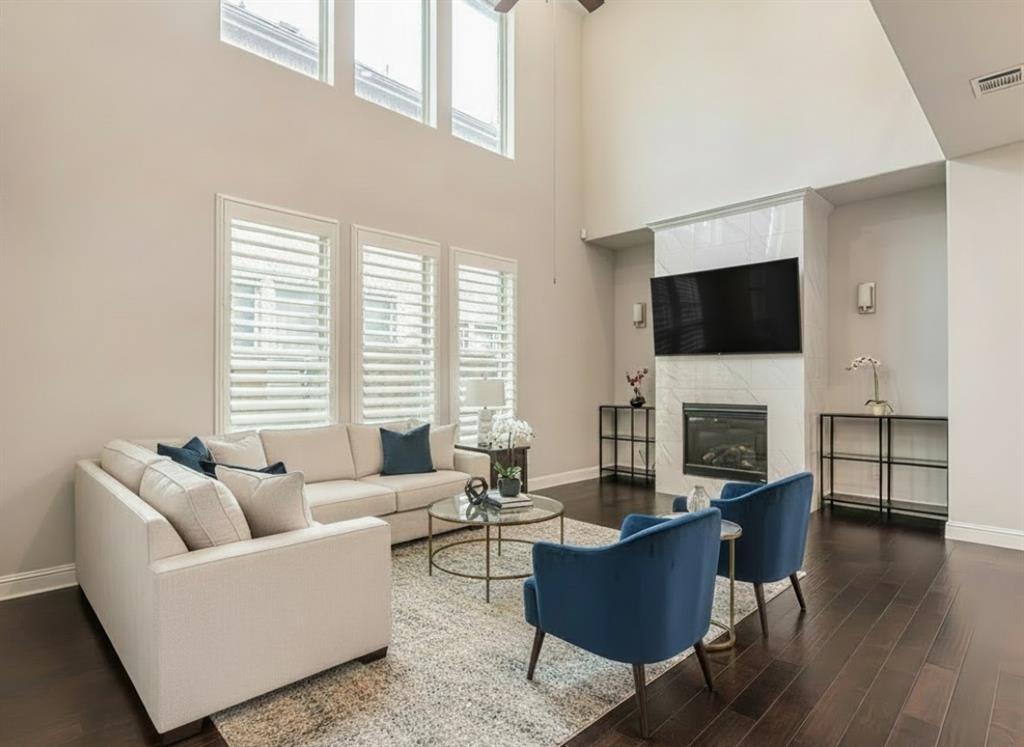 304 Adam Way Euless, TX 76040 - Photo 9 of 39 Living area with dark wood-style floors, plenty of natural light, a fireplace, and a high ceiling