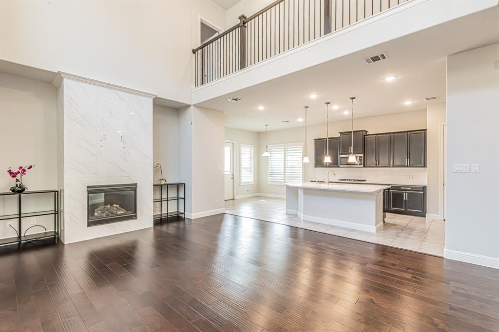 304 Adam Way Euless, TX 76040 - Photo 10 of 39 Unfurnished living room with a tile fireplace, light wood-style flooring, a high ceiling, and recessed lighting