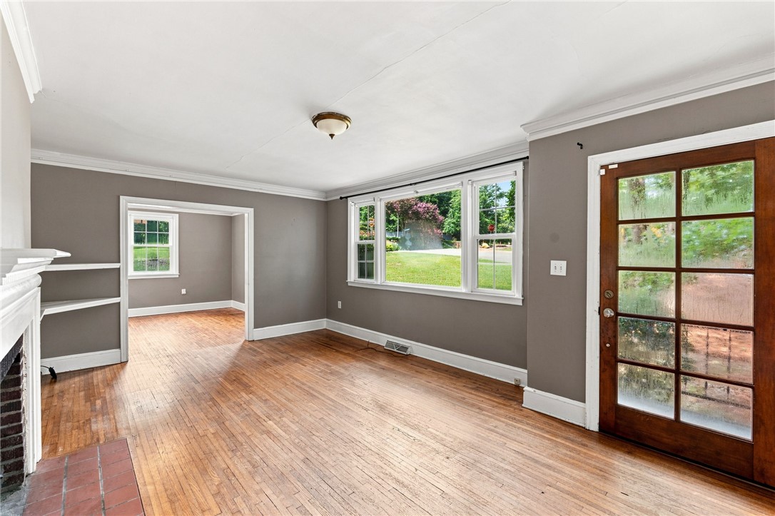 98 Blue Ridge Drive Clemson, SC 29631 - Photo 7 of 32 Rich hardwood flooring and classic crown molding frame a welcoming space looking out to the yard.
