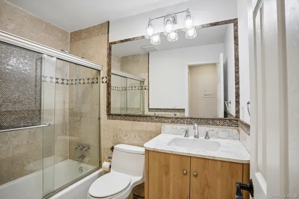 a bathroom with a sink toilet a mirror and shower