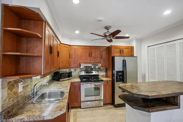 a kitchen with granite countertop a stove and a refrigerator