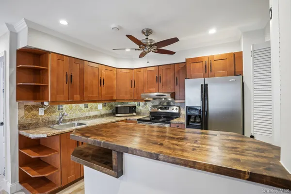 a kitchen with stainless steel appliances granite countertop a sink a stove and a refrigerator