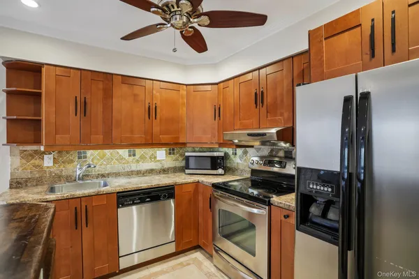 a kitchen with stainless steel appliances granite countertop a stove sink and cabinets
