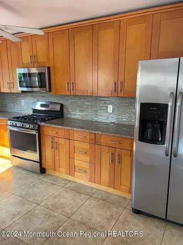 a kitchen with stainless steel appliances granite countertop a refrigerator a stove a sink and dishwasher