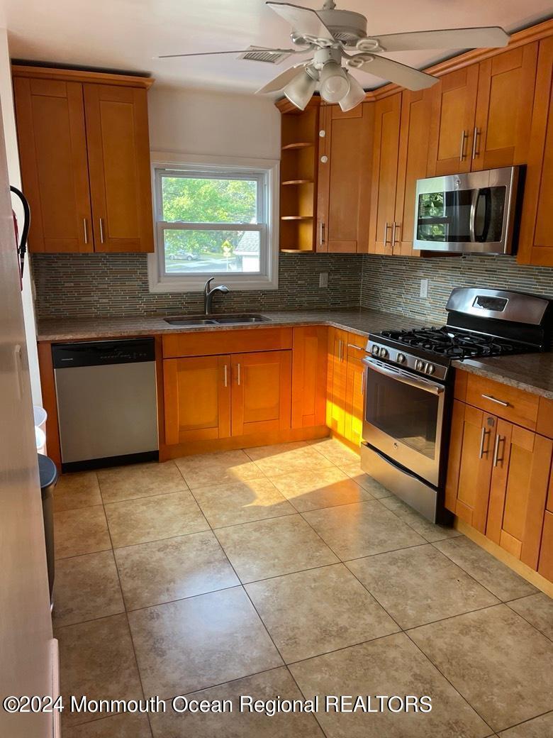 3 Berger Avenue Oakhurst, NJ 07755 - Photo 4 of 12 a kitchen with stainless steel appliances granite countertop a stove a sink and a microwave