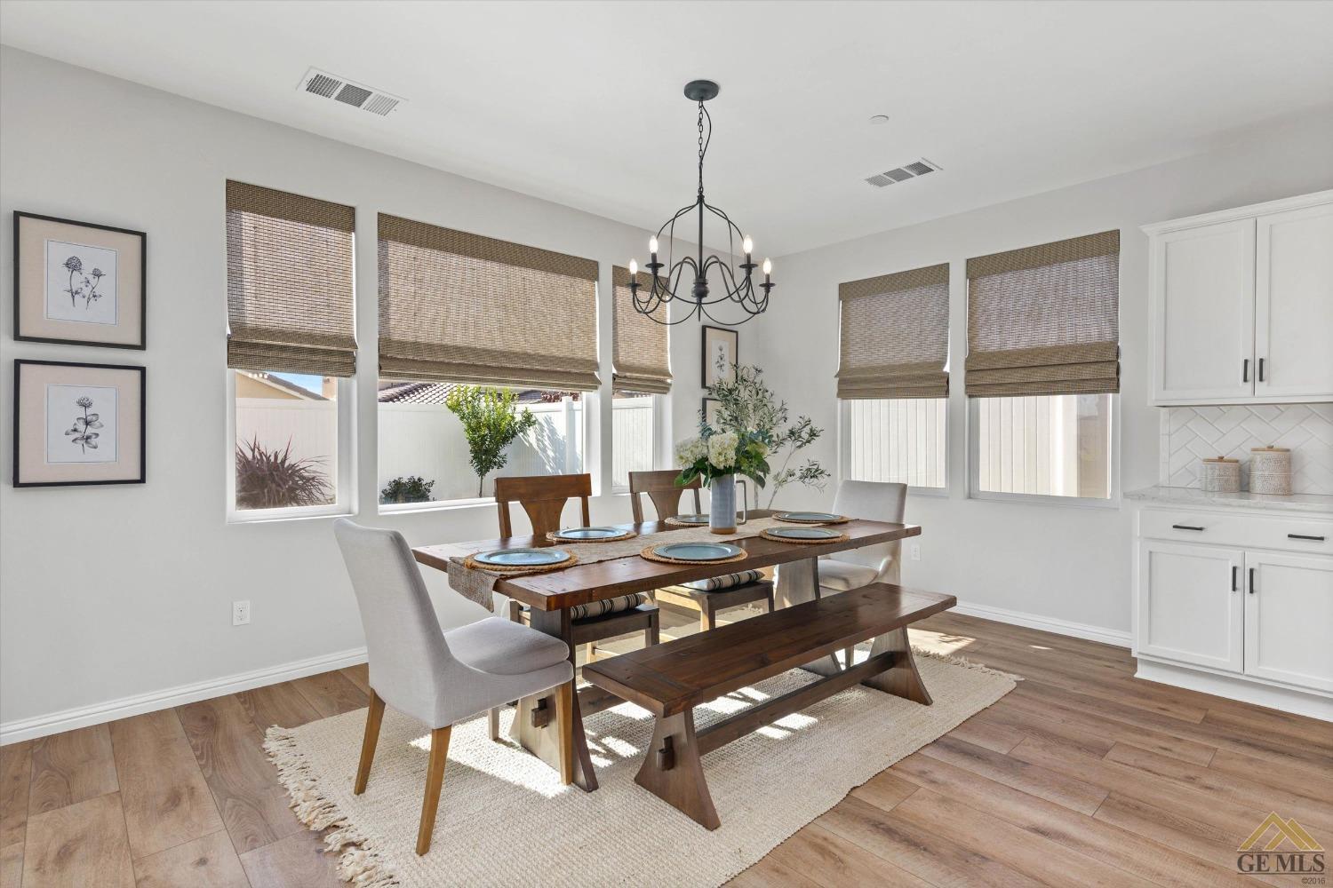 Undisclosed Address Bakersfield, CA 93311 - Photo 13 of 37 a dining room with wooden floor a chandelier a glass table and chairs