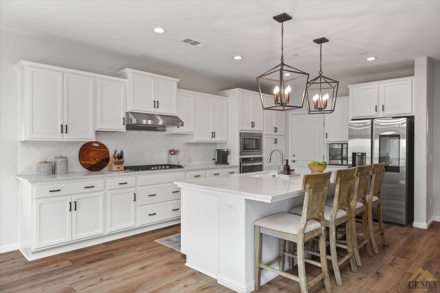 Undisclosed Address Bakersfield, CA 93311 - Photo 15 of 37 a kitchen with stainless steel appliances kitchen island granite countertop a table and chairs in it
