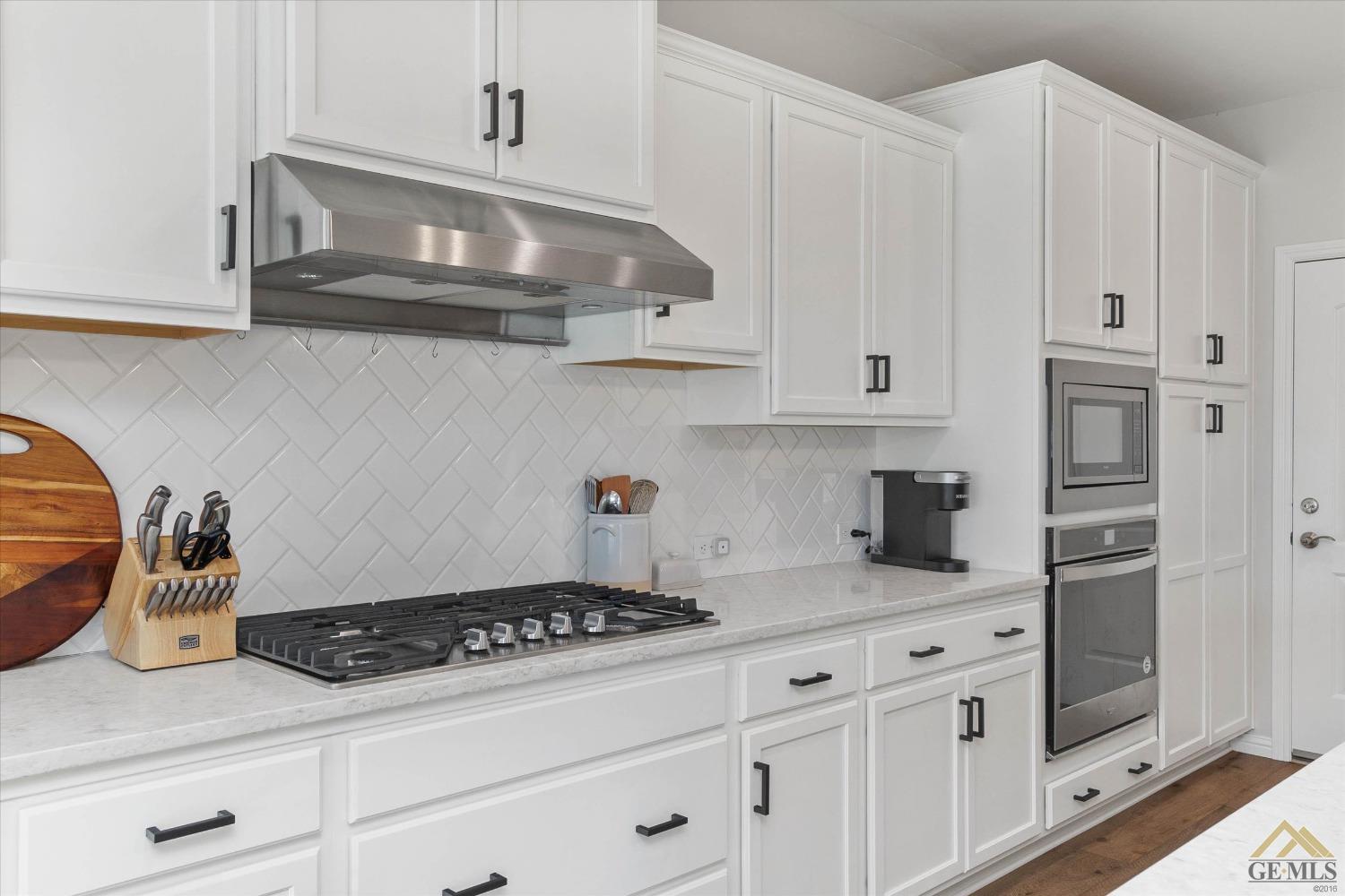 Undisclosed Address Bakersfield, CA 93311 - Photo 16 of 37 a kitchen with white cabinets and appliances