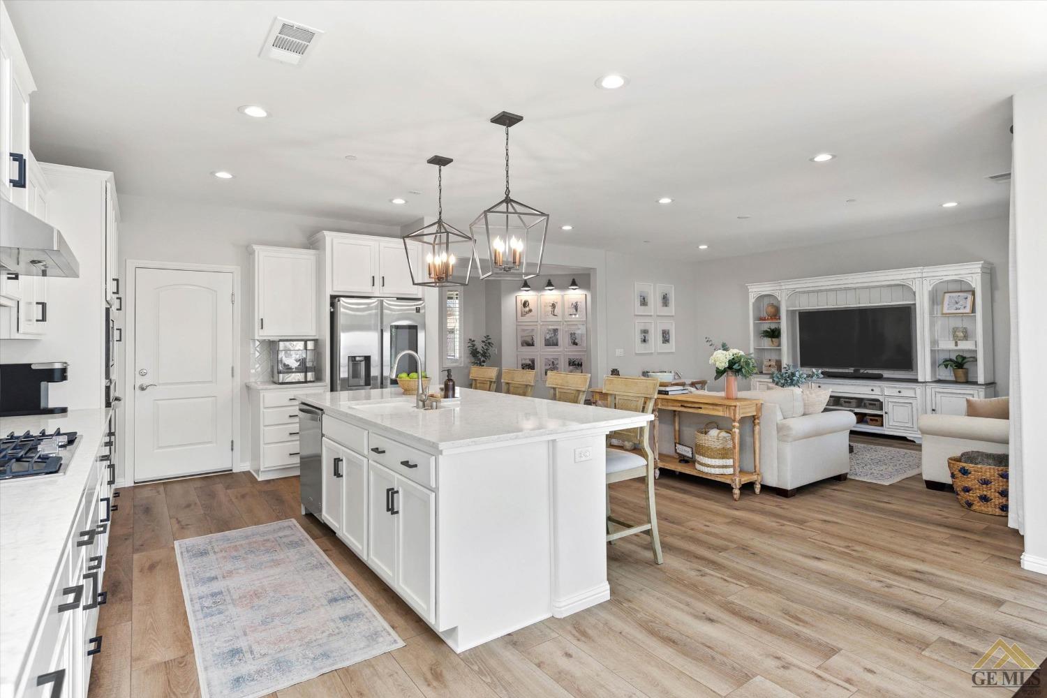 Undisclosed Address Bakersfield, CA 93311 - Photo 17 of 37 a large white kitchen with lots of counter space and chandelier