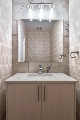 a bathroom with a granite countertop sink a mirror and vanity