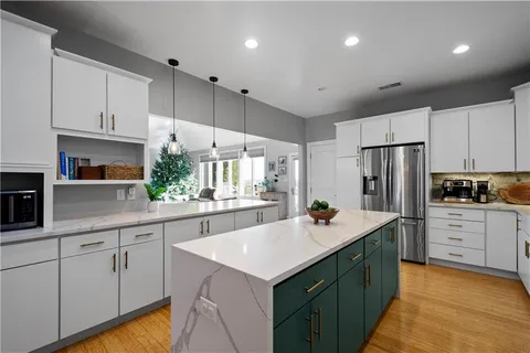 a kitchen with a sink stainless steel appliances and white cabinets