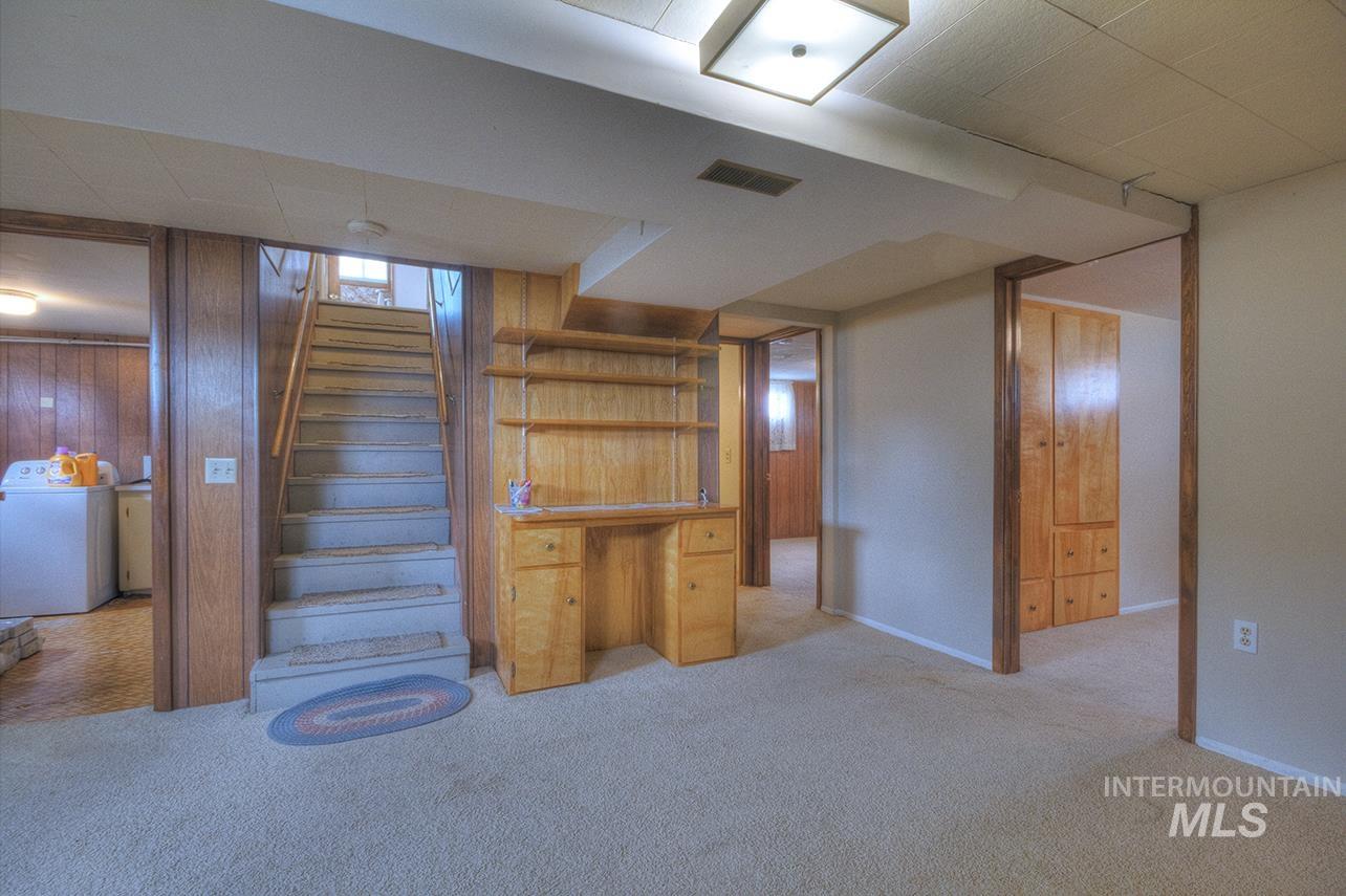 351 West Main Street South Vale, OR 97918 - Photo 15 of 33 Carpeted living area featuring wood-paneled walls and a built-in desk with shelving