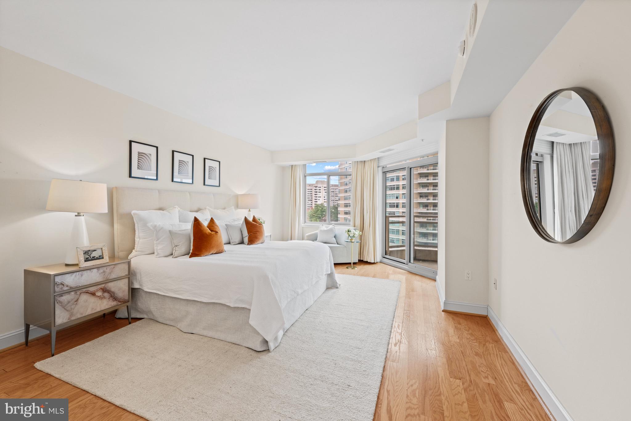 5630 Wisconsin Avenue, Unit 903 Chevy Chase, MD 20815 - Photo 21 of 50 a spacious bedroom with a bed a mirror and a window