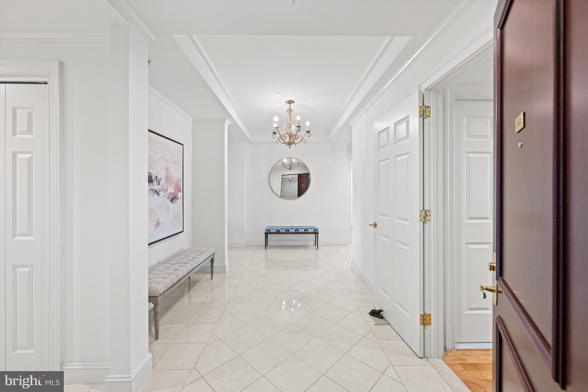 5630 Wisconsin Avenue, Unit 903 Chevy Chase, MD 20815 - Photo 7 of 50 a hallway with painting and a chandelier