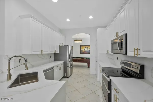 a kitchen with stainless steel appliances granite countertop a sink and a stove top oven with wooden floor
