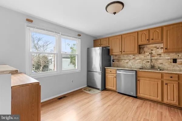 a kitchen with stainless steel appliances granite countertop a refrigerator sink and stove