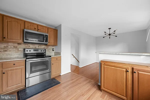 a kitchen with granite countertop cabinets stainless steel appliances and wooden floor