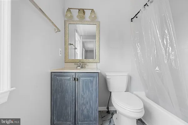 a bathroom with a toilet a sink a mirror and vanity