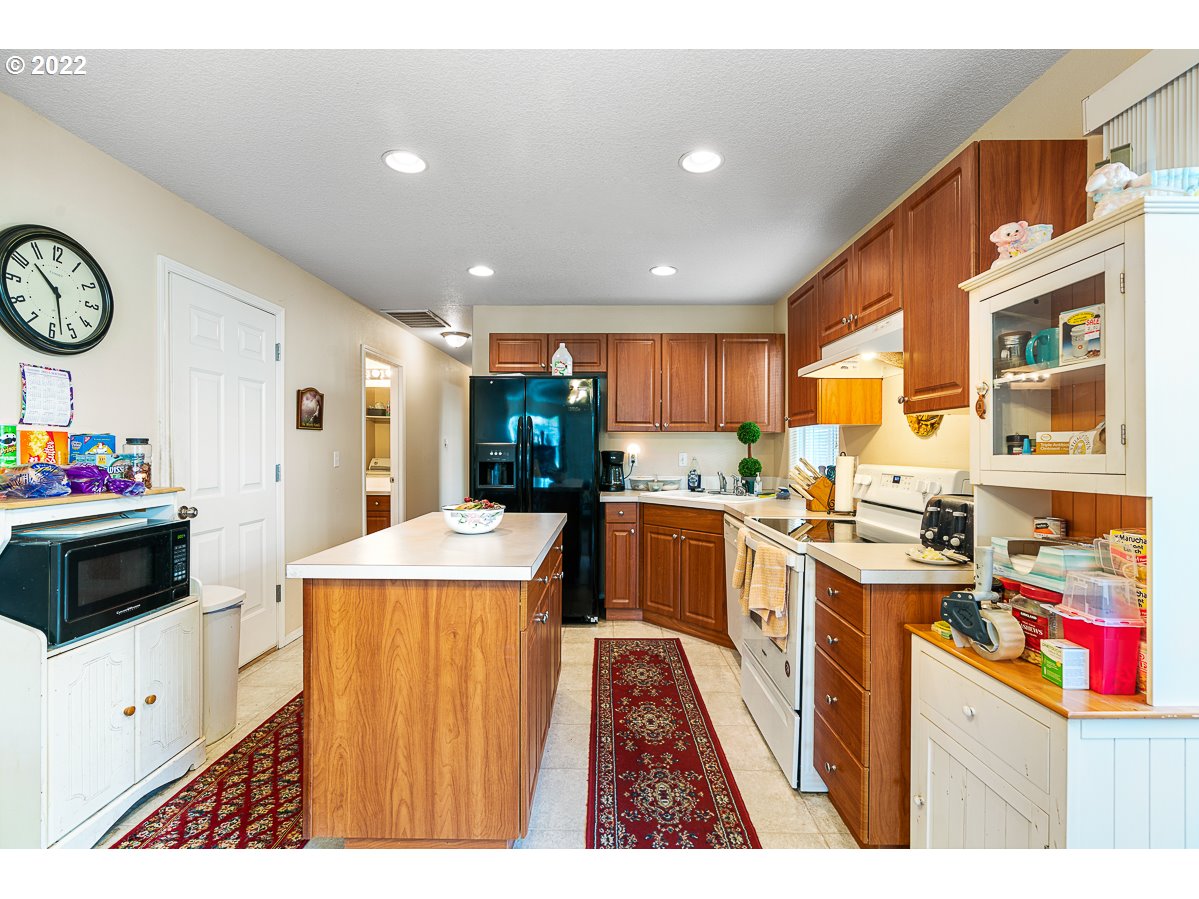 993 Southwest Junction Place Gresham, OR 97080 - Photo 6 of 27 a open kitchen with stainless steel appliances kitchen island granite countertop a stove and a sink