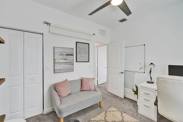 a living room with furniture and a ceiling fan
