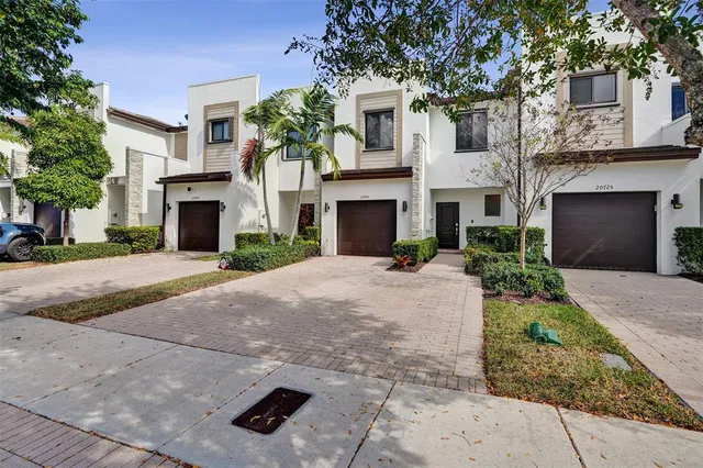 a front view of a house with yard and parking