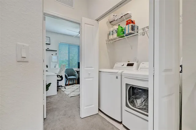 a utility room with dryer washer and a view of bathroom