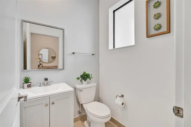 a bathroom with a toilet a sink and mirror