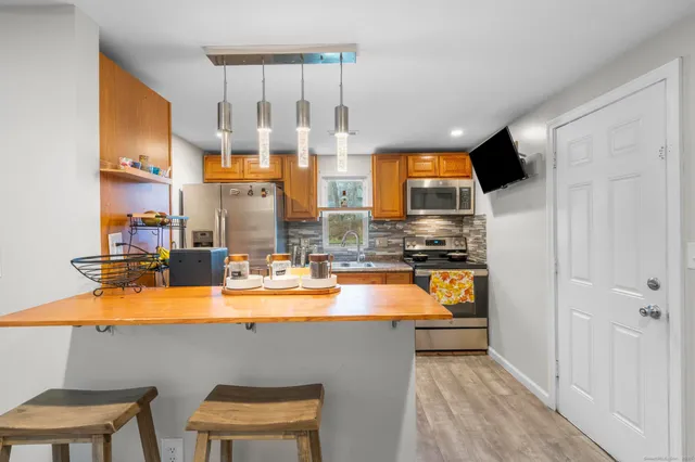 a kitchen with stainless steel appliances granite countertop a sink and a refrigerator
