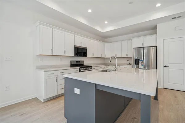 a kitchen with white cabinets sink and stove