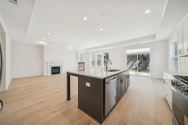 a kitchen with granite countertop a sink stainless steel appliances and cabinets