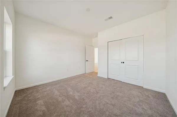 a view of a hallway with wooden floor and closet