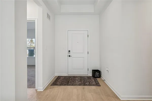 a view of an empty room with a fireplace and a window